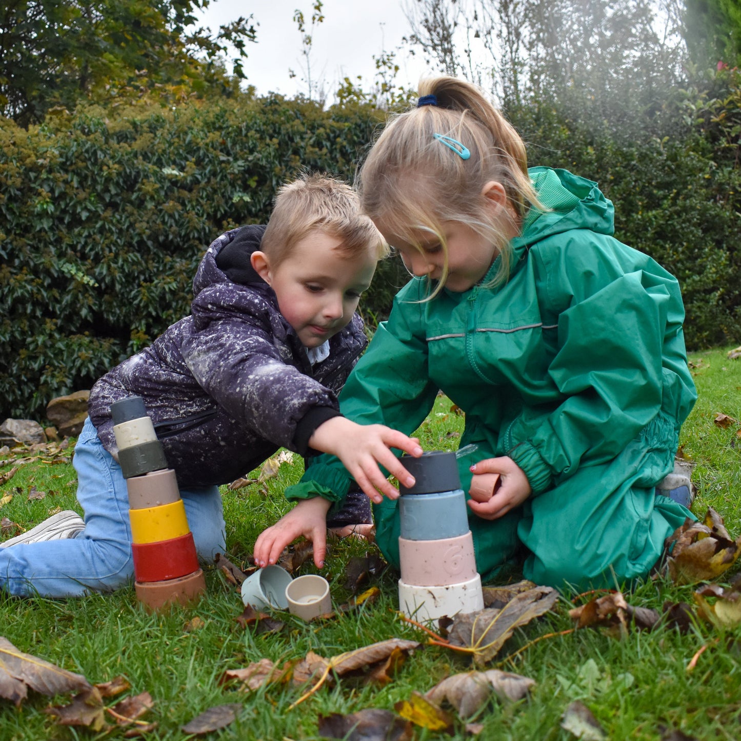 Baby playing with silicone stacking cups in neutral nursery